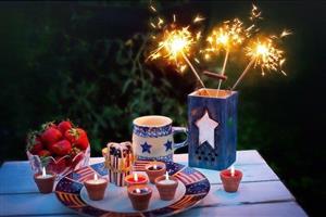 Table laid out with patriotic dishes, candles, and sparklers.